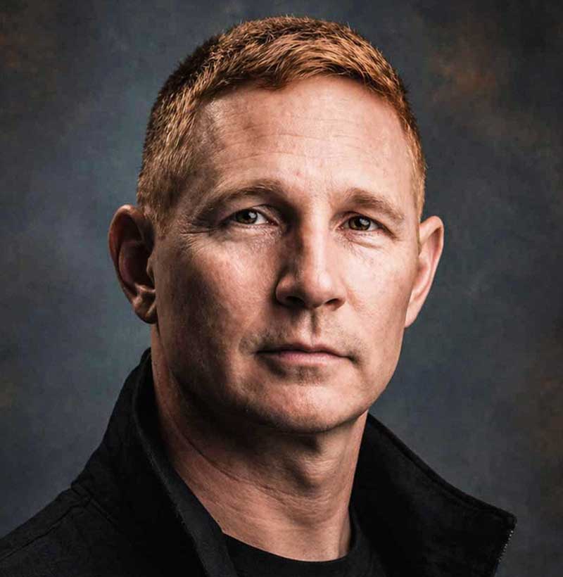 Headshot of Daniel Crandall Photographer with grunge painted studio background.